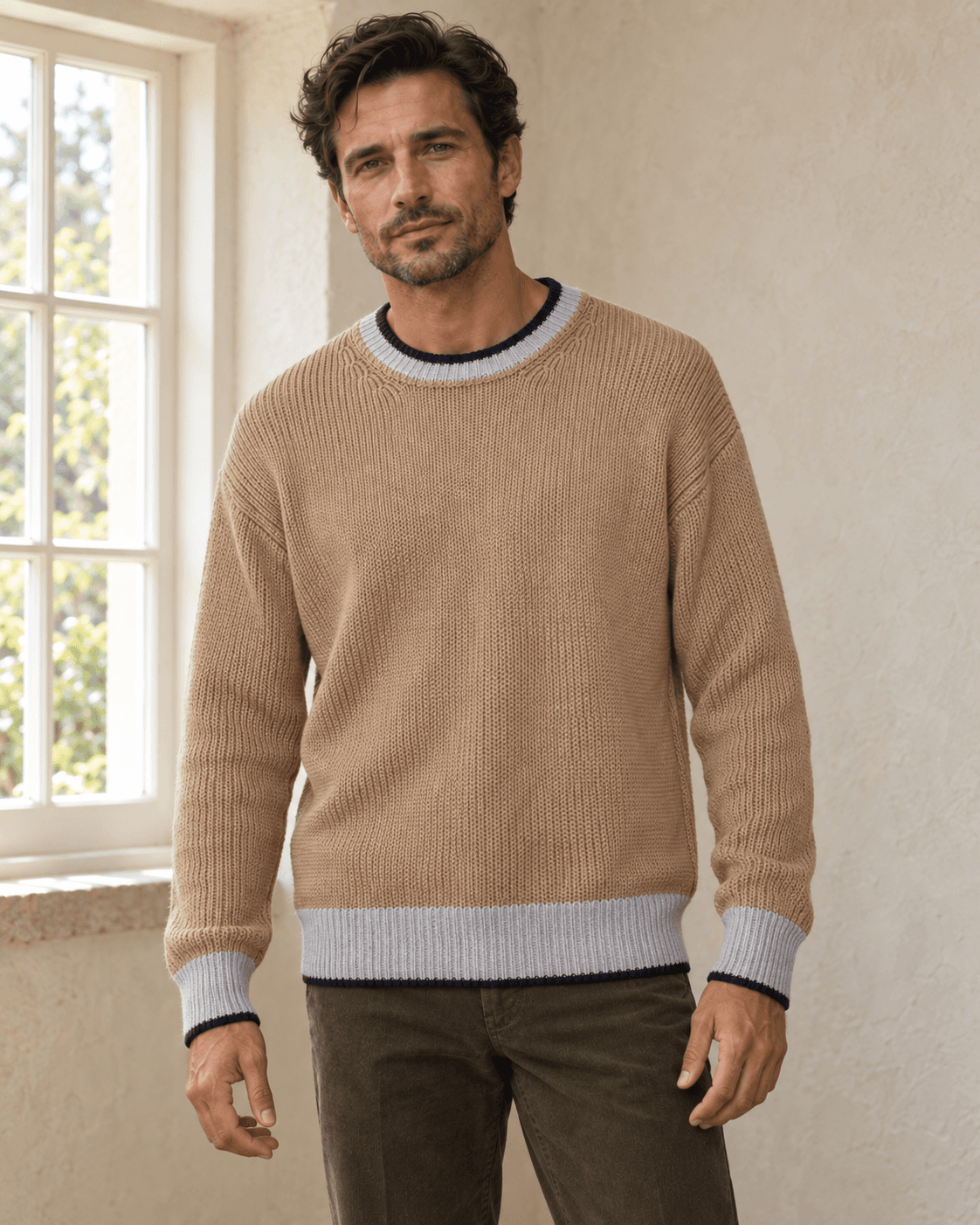 Modell framifrån i den beige bomullströjan med hals, ärmar och fåll fullt synliga.